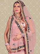 Bold colors created by the inventive drapes of textile catch the imagination like no other contemporary clothing. This dusty pink net a-line lehenga is nicely embroidered and velvet patch work is done with resham, stone and zardosi work. The beautiful embroidery on lehenga made it awesome and gives you stylish and attractive look to others. Matching choli and dupatta is availble with this lehenga. Slight Color variations are possible due to differing screen and photograph resolutions.