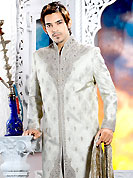 Make your collection more attractive with this dazzling sherwani. This off white sherwani embellished with sequins, beads, cutdana, heavy stone, zarkan, cutdana and patch work. The beautiful heavy embroidery on front border, collar, back and cuffs made it awesome and gives you stylish and attractive look to others. Matching churidar is enhanced your personality. This sherwani made with cotton silk fabric. Accessories shown in the image is just for photography purpose. Slight Color variations are possible due to differing screen and photograph resolutions.