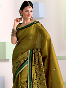 Make a trendy look with this classic embroidered saree. This olive green raw silk saree have beautiful embroidery patch work which is embellished with resham work. Fabulous designed embroidery gives you an ethnic look and increasing your beauty. Matching blouse is available. Slight Color variations are possible due to differing screen and photograph resolutions.