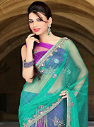 Attract all attentions with this embroidered saree. This green and purple net lehenga style saree have beautiful embroidery patch work which is embellished with zari, sequins, stone and cutbeads work. Fabulous designed embroidery gives you an ethnic look and increasing your beauty. Matching blouse is available. Slight Color variations are possible due to differing screen and photograph resolutions.
