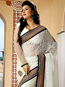 An endearing splash oh colors look gorgeous tridimensional charm. This off white net saree is nicely designed with embroidered patch work is done with resham, zari and stone work. Beautiful embroidery work on saree make attractive to impress all. This saree gives you a modern and different look in fabulous style. Matching blouse is available. Slight color variations are possible due to differing screen and photograph resolution.