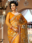 Keep the interest with this designer embroidery saree. This dark orange net saree is nicely designed with embroidery and velvet patch work is done with resham, zari, sequins, stone and lace work. Beautiful embroidery work on saree make attractive to impress all. This saree gives you a modern and different look in fabulous style. Matching blouse is available. Slight color variations are possible due to differing screen and photograph resolution.