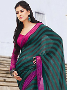 The most radiant carnival of style and beauty. This beautiful dark green and black faux georgette saree is nicely designed with stripe and floral print work. Beautiful print work on saree make attractive to impress all. It will enhance your personality and gives you a singular look. Contrasting pink blouse is available with this saree. Slight color variations are due to differing screen and photography resolution.