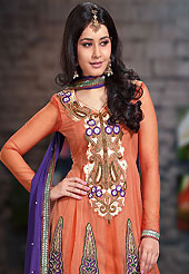 The glamorous silhouette to meet your most dire fashion needs. The dazzling deep peach net churidar suit have amazing embroidery patch work is done with resham, zari, sequins, stone and lace work. Beautiful embroidery work on kameez is stunning. The entire ensemble makes an excellent wear. Contrasting purple santoon churidar and dupatta is available with this suit. Slight Color variations are possible due to differing screen and photograph resolutions.