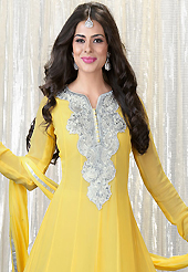 Look stunning rich with dark shades and floral patterns. The dazzling yellow faux georgette churidar suit have amazing embroidery patch work is done with resham, sequins and gota patti lace work. Beautiful embroidery work on kameez is stunning. The entire ensemble makes an excellent wear. Matching santoon churidar and chiffon dupatta is available with this suit. Slight Color variations are possible due to differing screen and photograph resolutions.