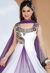 Look stunning rich with dark shades and floral patterns. The dazzling white and purple net readymade churidar suit have amazing embroidery patch work is done with zari, stone and cutdana work. The entire ensemble makes an excellent wear. Matching purple santoon churidar and purple net dupatta is available with this suit. Slight Color variations are possible due to differing screen and photograph resolutions.
