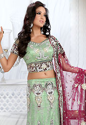 Outfit is a novel ways of getting yourself noticed. This celedon green net lehenga is nicely embroidered and velvet patch work is done with stone, zardosi, cutdana and cutbeads work. The beautiful embroidery on lehenga made it awesome and gives you stylish and attractive look to others. Matching choli and dark pink net dupatta is availble with this lehenga. Slight Color variations are possible due to differing screen and photograph resolutions.