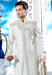 Emblem of fashion and style, each piece of our range of designer sherwani is certain to enhance your look as per todays trends. This off white royal look traditional sherwani designed with cutdana, pearl, beads, all over stone and patch work. The beautiful embroidery on front border, collar, back and cuffs made it awesome and gives you stylish and attractive look to others. Matching churidar is enhanced your personality. This sherwani made with brocade fabric. Accessories shown in the image is just for photography purpose. Slight Color variations are possible due to differing screen and photograph resolutions.