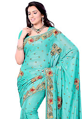The evolution of style species collection spells pure femininity. This aqua blue shimmer georgette saree is nicely designed with embroidered patch work in fabulous style. Embroidery is done with sequins, kasab and cutdana work in form of floral motifs. Beautiful hand embroidery work on saree make attractive to impress all. This saree gives you a modern and different look in fabulous style. Matching blouse is available with this saree. Slight color variations are possible due to differing screen and photograph resolution.