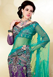 Try out this year top trend, glowing, bold and natural collection. This turquoise and purple net lehenga style saree is nicely designed with embroidered patch work is done with zari, stone, cutbeads and lace work. Saree gives you a singular and dissimilar look. Matching purple blouse is available. Slight color variations are possible due to differing screen and photograph resolution.