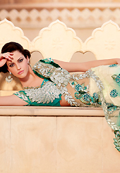 An occasion wear perfect is ready to rock you. This light cream and turquoise green net lehenga style saree is nicely designed with heavy embroidered patch work is done with resham, zari, sequins, stone and lace work. Beautiful embroidery patch border on saree make attractive to impress all. This saree gives you a modern and different look in fabulous style. Matching blouse is available with this saree. Slight color variations are possible due to differing screen and photograph resolution.