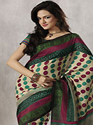 It is color this season and bright shaded suits are really something that is totally in vogue. This beautiful cream, green and dark pink art silk saree is nicely designed with polka dots, abstract and geometric print work. Beautiful print work on saree make attractive to impress all. It will enhance your personality and gives you a singular look. Matching green blouse is available with this saree. Slight color variations are due to differing screen and photography resolution.