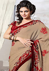 Exquisite combination of color, fabric can be seen here. This light brown faux chiffon saree is nicely designed with embroidered patch work is done with resham and stone work. Saree gives you a singular and dissimilar look. Contrasting maroon blouse is available. Slight color variations are possible due to differing screen and photograph resolution.