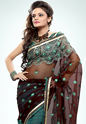 Get ready to sizzle all around you by sparkling saree. This deep brown and teal green net and georgette saree is nicely designed with embroidered patch work is done with resham, zari and sequins work. Saree gives you a singular and dissimilar look. Matching blouse is available. Slight color variations are possible due to differing screen and photograph resolution.