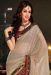 Dreamy variation on shape and forms compliment your style with tradition. This beige and maroon art silk and viscose saree is nicely designed with embroidered patch work is done with resham, zari and sequins work. Saree gives you a singular and dissimilar look. Matching maroon blouse is available. Slight color variations are possible due to differing screen and photograph resolution.