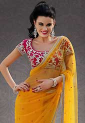 Attract all attentions with this embroidered saree. This dark yellow net saree is nicely designed with embroidered patch work is done with stone work. Beautiful embroidery work on saree make attractive to impress all. This saree gives you a modern and different look in fabulous style. Contrasting pink blouse is available. Slight color variations are possible due to differing screen and photograph resolution.