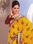 Dreamy variation on shape and forms compliment your style with tradition. This beautiful yellow chiffon saree is nicely designed with floral, paisley print, zari and graceful patch border. Beautiful print work on saree make attractive to impress all. It will enhance your personality and gives you a singular look. Contrasting maroon blouse is available with this saree. Slight color variations are due to differing screen and photography resolution.