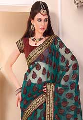 Exquisite combination of color, fabric can be seen here. This beautiful teal green tissue saree is nicely designed with velvet, gold print, zari, lace and graceful patch border. Beautiful print work on saree make attractive to impress all. It will enhance your personality and gives you a singular look. Contrasting maroon blouse is available with this saree. Slight color variations are due to differing screen and photography resolution.