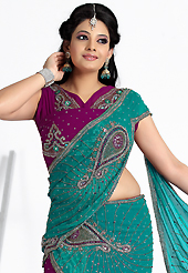 Envelope yourself in classic look with this charming saree. This turquoise green and dark magenta faux georgette lehenga style saree have beautiful embroidery patch work which is embellished with stone and cutdana work. Fabulous designed embroidery gives you an ethnic look and increasing your beauty. Matching blouse is available. Slight Color variations are possible due to differing screen and photograph resolutions.