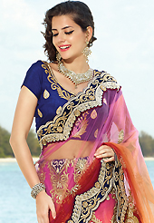 Get ready to sizzle all around you by sparkling saree. This pink and shaded orange net lehenga style saree is nicely designed with embroidered patch work is done with resham, zari, stone and beads work. Saree gives you a singular and dissimilar look. Contrasting dark blue blouse is available. Slight color variations are possible due to differing screen and photograph resolution.