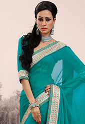 The most beautiful refinements for style and tradition. This turquoise faux chiffon saree is nicely designed with embroidered patch work is done with zari and stone work. Saree gives you a singular and dissimilar look. Matching blouse is available. Slight color variations are possible due to differing screen and photograph resolution.
