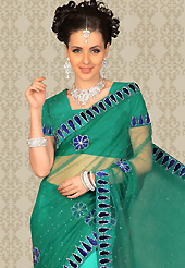 Exquisite combination of color, fabric can be seen here. This turquoise green net saree is nicely designed with embroidered and velvet patch work is done with resham and stone work. This saree gives you a modern and different look in fabulous style. Matching blouse is available with this saree. Slight color variations are possible due to differing screen and photograph resolution.