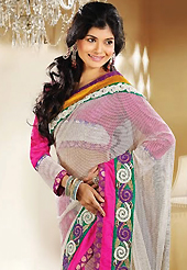 The fascinating beautiful subtly garment with lovely patterns. This off white and magenta shimmer net and brocade saree is nicely designed with embroidery patch work is done with resham, zari, sequins, stone and beads work. Beautiful embroidery work on saree make attractive to impress all. This saree gives you a modern and different look in fabulous style. Matching blouse is available. Slight color variations are possible due to differing screen and photograph resolution.