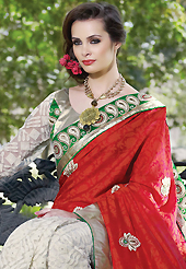 The evolution of style species collection spells pure femininity. This red and off white art silk jacquard and net saree have beautiful embroidery patch work which is embellished with resham, stone, beads and lace work. Fabulous designed embroidery gives you an ethnic look and increasing your beauty. Contrasting green and off white art silk and net blouse is available. Slight Color variations are possible due to differing screen and photograph resolutions.