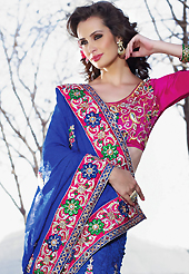 Exquisite combination of color, fabric can be seen here. This shaded blue faux georgette jacquard and net lehenga style saree have beautiful embroidery patch work which is embellished with resham, zari and stone work. Fabulous designed embroidery gives you an ethnic look and increasing your beauty. Contrasting dark pink art silk blouse is available. Slight Color variations are possible due to differing screen and photograph resolutions.