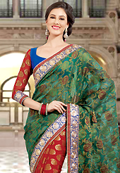 Style and trend will be at the peak of your beauty when you adorn this saree. This dark green and red dupion and viscose saree have beautiful embroidery patch work which is embellished with resham and zari work. Fabulous designed embroidery gives you an ethnic look and increasing your beauty. Contrasting blue and red blouse is available. Slight Color variations are possible due to differing screen and photograph resolutions.