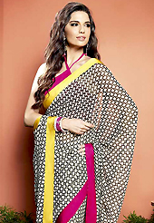 Printed sarees are the best choice for a girl to enhance her feminine look. This beautiful black and off white faux georgette saree is nicely designed with geometric print and graceful patch border. Beautiful print work on saree make attractive to impress all. It will enhance your personality and gives you a singular look. Contrasting dark pink blouse is available with this saree. Slight color variations are due to differing screen and photography resolution.