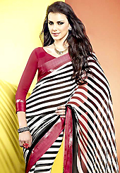 Get ready to sizzle all around you by sparkling saree. This beautiful off white and black faux georgette saree is nicely designed with stripe print work. Beautiful print work on saree make attractive to impress all. It will enhance your personality and gives you a singular look. Contrasting red blouse is available with this saree. Slight color variations are due to differing screen and photography resolution.