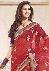 Get ready to sizzle all around you by sparkling saree. This red silk saree is nicely designed with embroidered patch work is done with zari work. This saree gives you a modern and different look in fabulous style. Contrasting purple blouse is available. Slight color variations are possible due to differing screen and photograph resolution.