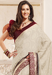 It is color this season and bright shaded suits are really something that is totally in vogue. This off white jacquard saree is nicely designed with embroidered patch work is done with resham and zari work. This saree gives you a modern and different look in fabulous style. Contrasting maroon blouse is available. Slight color variations are possible due to differing screen and photograph resolution.