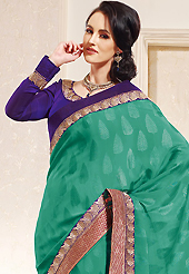 The evolution of style species collection spells pure femininity. This green faux crepe jacquard saree is nicely designed with embroidered patch work is done with zari work. This saree gives you a modern and different look in fabulous style. Contrasting purple blouse is available. Slight color variations are possible due to differing screen and photograph resolution.