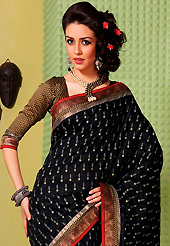 Exquisite combination of color, fabric can be seen here. This black art silk saree is nicely designed with floral print, self weaving zari, lace and patch bordered work. Beautiful embroidery work on saree make attractive to impress all. This saree gives you a modern and different look in fabulous style. Matching blouse is available. Slight color variations are possible due to differing screen and photograph resolution.