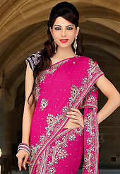 Look stunning rich with dark shades and floral patterns. This dark pink and deep purple satin chiffon and velvet lehenga style saree have beautiful embroidery patch work which is embellished with sequins, stone, cutdana and cutbeads work. Fabulous designed embroidery gives you an ethnic look and increasing your beauty. Matching blouse is available. Slight Color variations are possible due to differing screen and photograph resolutions.