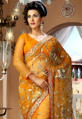 Keep the interest with this designer embroidery saree. This dark orange net saree is nicely designed with embroidery and velvet patch work is done with resham, zari, sequins, stone and lace work. Beautiful embroidery work on saree make attractive to impress all. This saree gives you a modern and different look in fabulous style. Matching blouse is available. Slight color variations are possible due to differing screen and photograph resolution.