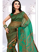 Try out this year top trends, glowing, bold and natural collection. This pastel green and mustard net printed casual wear saree have beautiful floral and butti print work on all over. Border has amazing contrasting fabric lace. It’s cool and has a very modern look to impress all. Matching blouse is available.  Slight Color variations are possible due to differing screen and photograph resolutions.
