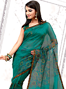 Envelope yourself in classic look with this charming saree. This turquoise net printed casual wear saree have beautiful floral print work on all over. Border has amazing contrasting fabric lace. It’s cool and has a very modern look to impress all. Matching blouse is available.  Slight Color variations are possible due to differing screen and photograph resolutions.